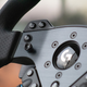 Close up on left-side controls and directional stick on Logitech G Pro steering wheel.